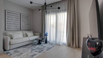 Ein modernes Wohnzimmer mit einer Couch, einem gemusterten Teppich und einer dekorativen Lampe.