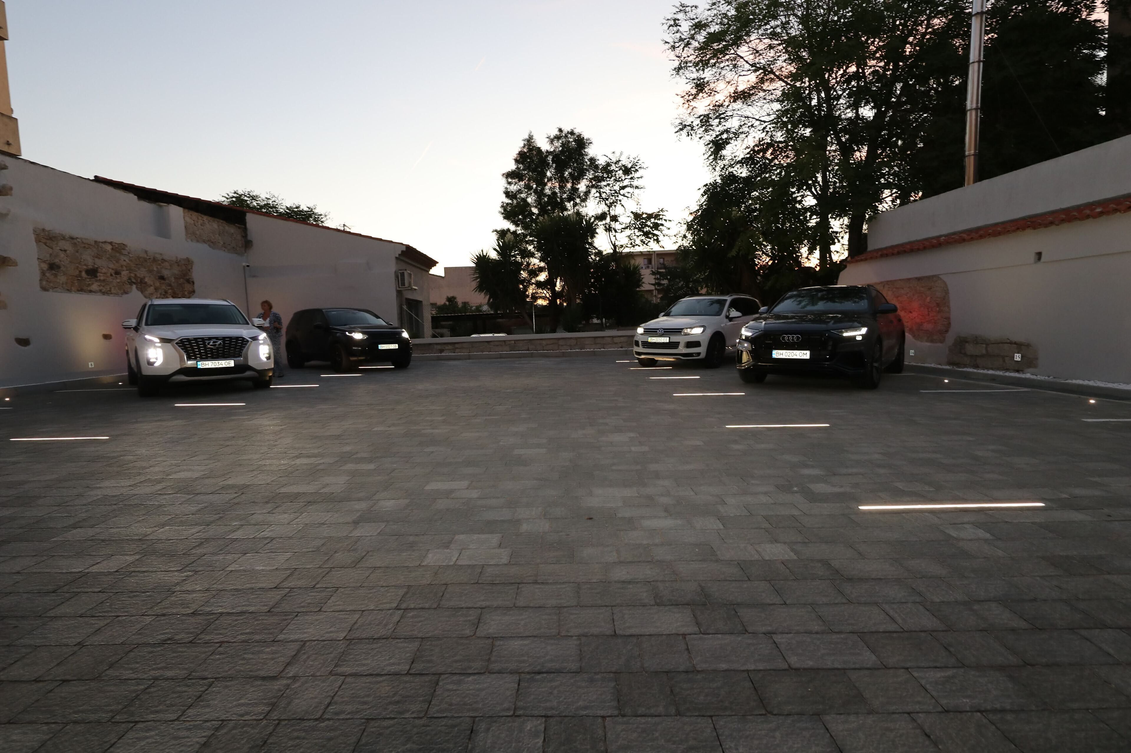 A parking area with four cars parked in a row.