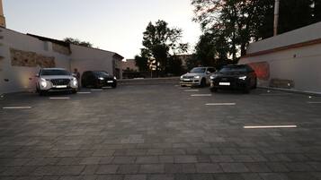 A parking area with four cars parked in a row.