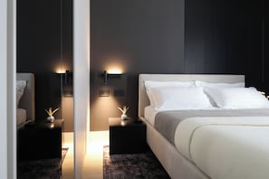 Ein modernes Schlafzimmer mit einem großen Bett, Nachttischen und Wandleuchten.