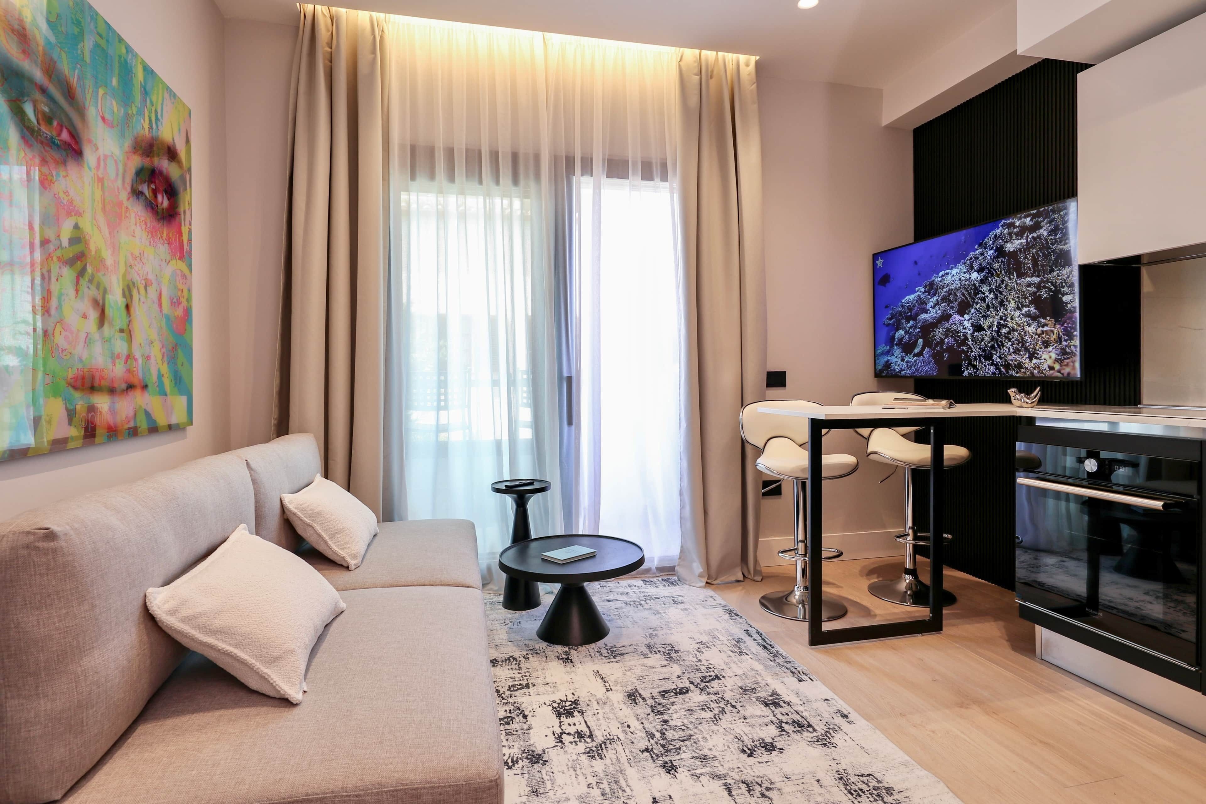 Un soggiorno moderno con divano, tavolino e televisore.