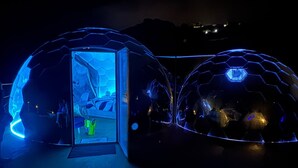 Two geodesic domes with a central open area, likely a lobby or entrance, and a small seating area visible inside one dome. - Palmaria Sky Bubbles Room - Sleep Under the Stars in a Dream Bubble Room (Ponza)