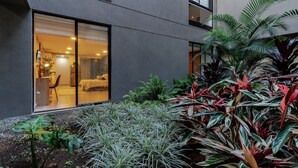 A modern building with a large glass door leading to a well-lit interior. - Loft with garden view for natural relaxation (Medellín)
