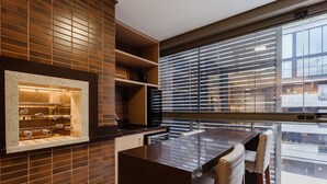 A modern kitchen with a built-in wine rack, a large window with blinds, and a bar area with stools. - Beautiful apt Less Than 5min From the Beach Vrn302 (Florianópolis)