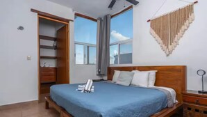 A bedroom with a wooden bed, a blue bedspread, and a wooden nightstand.