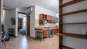 A spacious kitchen with wooden cabinets, a built-in oven, and a dining area with stools.