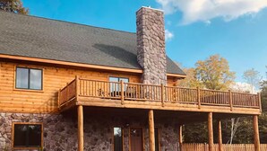 A log cabin with a stone chimney, a balcony, and a stone exterior. - Modern 3BR/4BA Windham chalet w/ hot tub, views & mins to ski, bars, dining! (Windham)