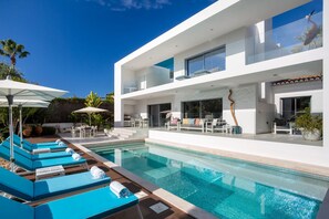 A modern two-story house with a swimming pool, outdoor seating, and a view of the sky. - Deluxe Ancao - Four Bedroom Villa, Sleeps 8 (Almansil)