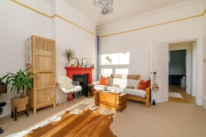Un salon avec une cheminée, un canapé et un tapis en peau de vache.
