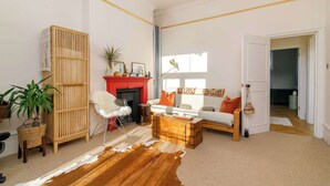 A living room with a fireplace, sofa, coffee table, and a cowhide rug.