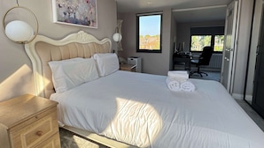 Ein Schlafzimmer mit einem großen Bett, einem Schreibtisch und einem Stuhl.