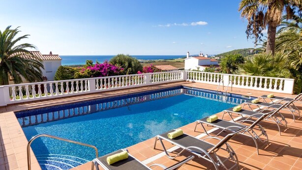A swimming pool with lounge chairs and a view of the sea. - Villa Los Leones - Three Bedroom Villa, Sleeps 6 (Alayor)