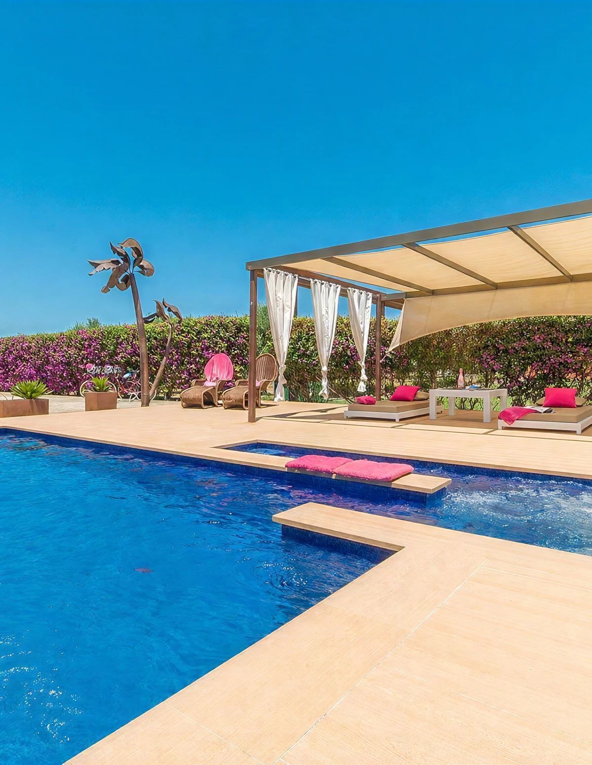 A pool area with a covered seating area and a decorative metal sculpture.