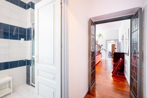 A hallway with a white door, a bench, and a staircase.