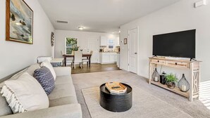 A modern living room with a sofa, a coffee table, and a TV on a stand.