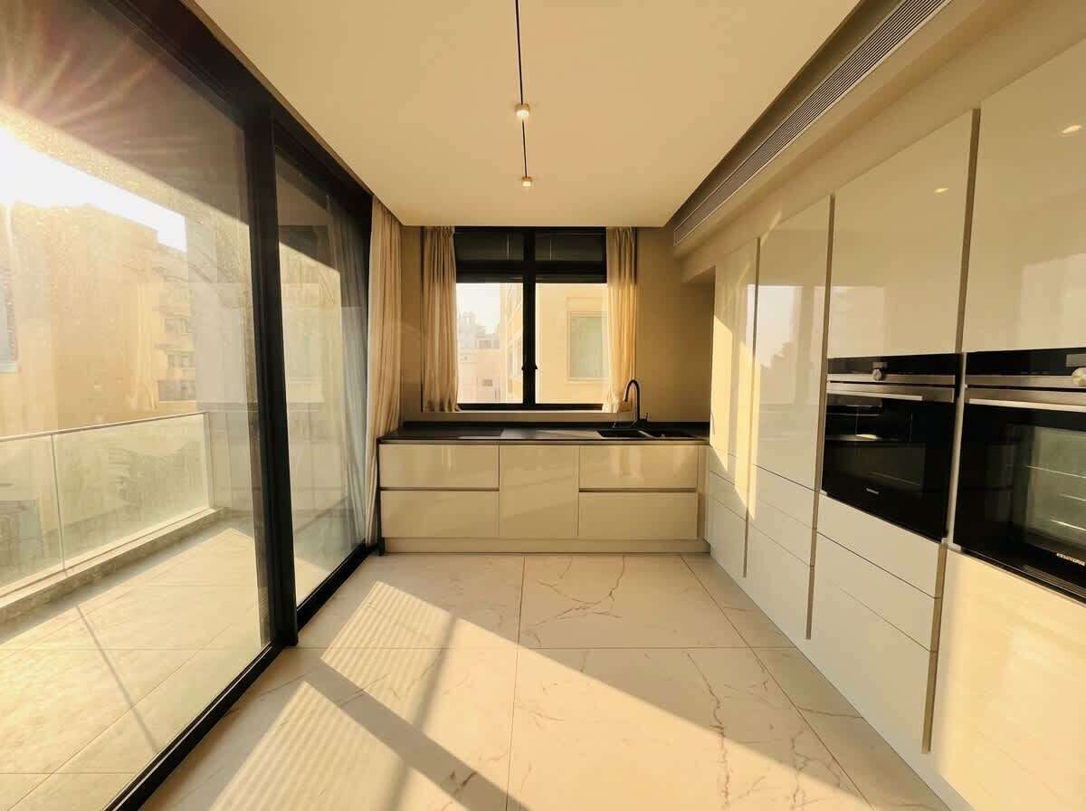Una cocina moderna con un ventanal grande, horno empotrado y vistas a la ciudad.