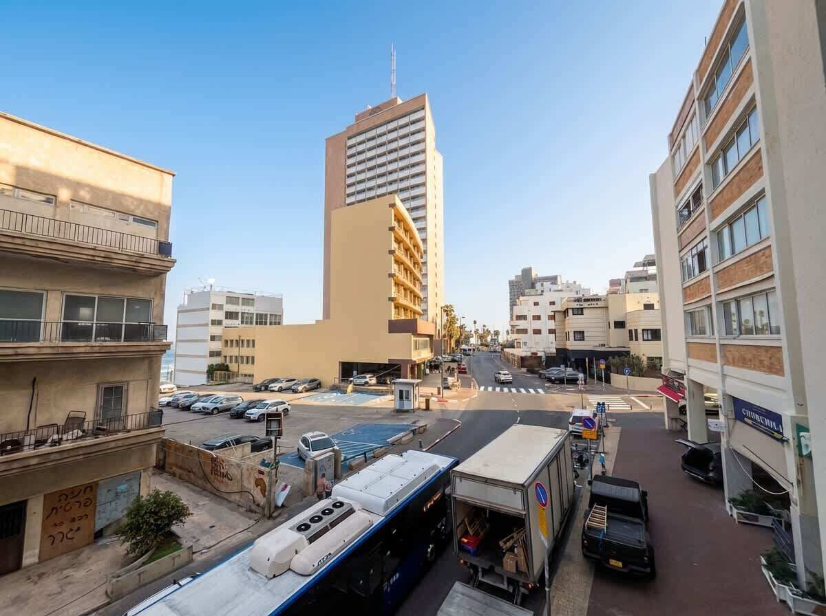 Eine Stadtstraße mit Gebäuden, parkenden Autos und einem Bus.