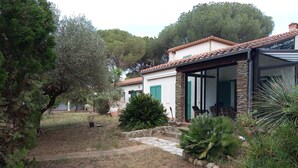 A house with a stone facade, green shutters, and a covered patio with outdoor furniture. - Large villa with 11x5m pool in 7700 M2 grounds. Veranda and multiple terraces. (Montescot)