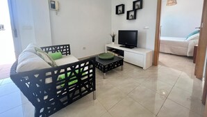 A modern living room with a sofa, a TV, and a dining table. - Vacation 'Sol Y Mar' with Sea View, Wi-Fi and Air Conditioning (Arguineguín)