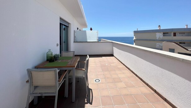 A balcony with a table and chairs, a potted plant, and a view of the sea. - Vacation 'Sol Y Mar' with Sea View, Wi-Fi and Air Conditioning (Arguineguín)