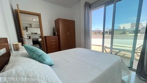 A bedroom with a bed, a wardrobe, a mirror, and a view of the outside. - Vacation 'Sol Y Mar' with Sea View, Wi-Fi and Air Conditioning (Arguineguín)