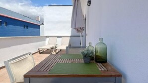 A balcony with a table, chairs, and two green bottles. - Vacation 'Sol Y Mar' with Sea View, Wi-Fi and Air Conditioning (Arguineguín)