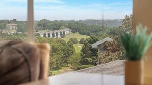 A room with a view of a golf course, a window, and a plant on the windowsill. - Golf View Getaway – For 6 (Branson)