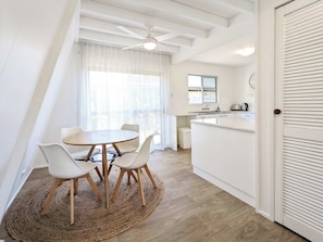 Een moderne keuken met witte kasten, een inbouw-kookeiland en een raam met uitzicht.