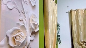 Een muur met een bloemenpatroon en een gordijn.