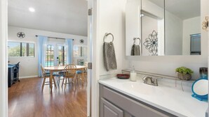 A modern kitchen with a white countertop, a sink, and a large mirror. - Private Guesthouse w/ Pool in Historic Wickenburg! (Wickenburg)