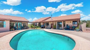 A pool area with a clear blue pool, surrounded by a covered patio with outdoor seating. - Private Guesthouse w/ Pool in Historic Wickenburg! (Wickenburg)