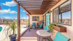 A patio with a pergola, outdoor seating, potted plants, and a view of the surrounding area. - Private Guesthouse w/ Pool in Historic Wickenburg! (Wickenburg)