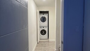 A narrow hallway with a washing machine and dryer at the end. - Delightful 3-bedroom house with Sunset views (Homestead)