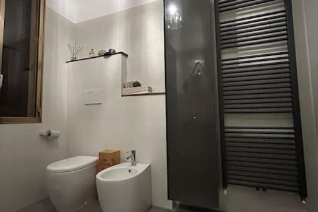 A bathroom with a toilet, bidet, and a mirror.