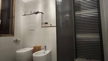 A bathroom with a toilet, bidet, and a mirror.