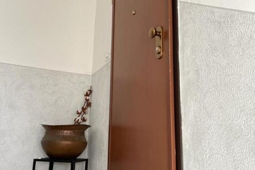Une porte marron fermée, dotée d’une poignée en laiton et d’une petite plaque en laiton fixée au-dessus.
