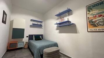 Ein kleines, modernes Schlafzimmer mit einem Bett, einer Bank und Wandregalen.