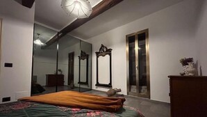 Une chambre à coucher avec un grand lit, un miroir et une commode.
