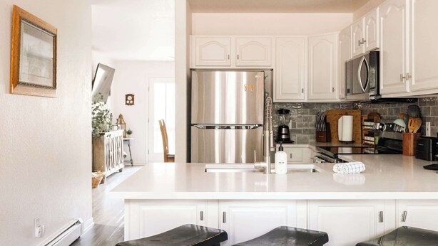 A modern kitchen with white cabinets, stainless steel appliances, and a central island. - Explore, Relax, Repeat | Riverside Views | Eagle (Eagle)