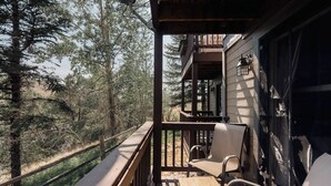 A wooden deck with a table and chairs, overlooking a forested area. - Explore, Relax, Repeat | Riverside Views | Eagle (Eagle)
