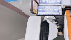 Un couloir étroit avec une enseigne indiquant l’hôtel Sana, au 6e étage.