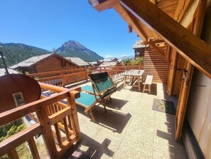 A wooden deck with a pool, outdoor seating, and mountain views. - 100m from ski slopes, 1st floor, terrace, tv, ski locker, 50m², Montgenèvre (Montgenèvre)