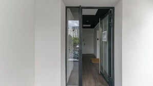 A narrow hallway with a glass door leading to a balcony.