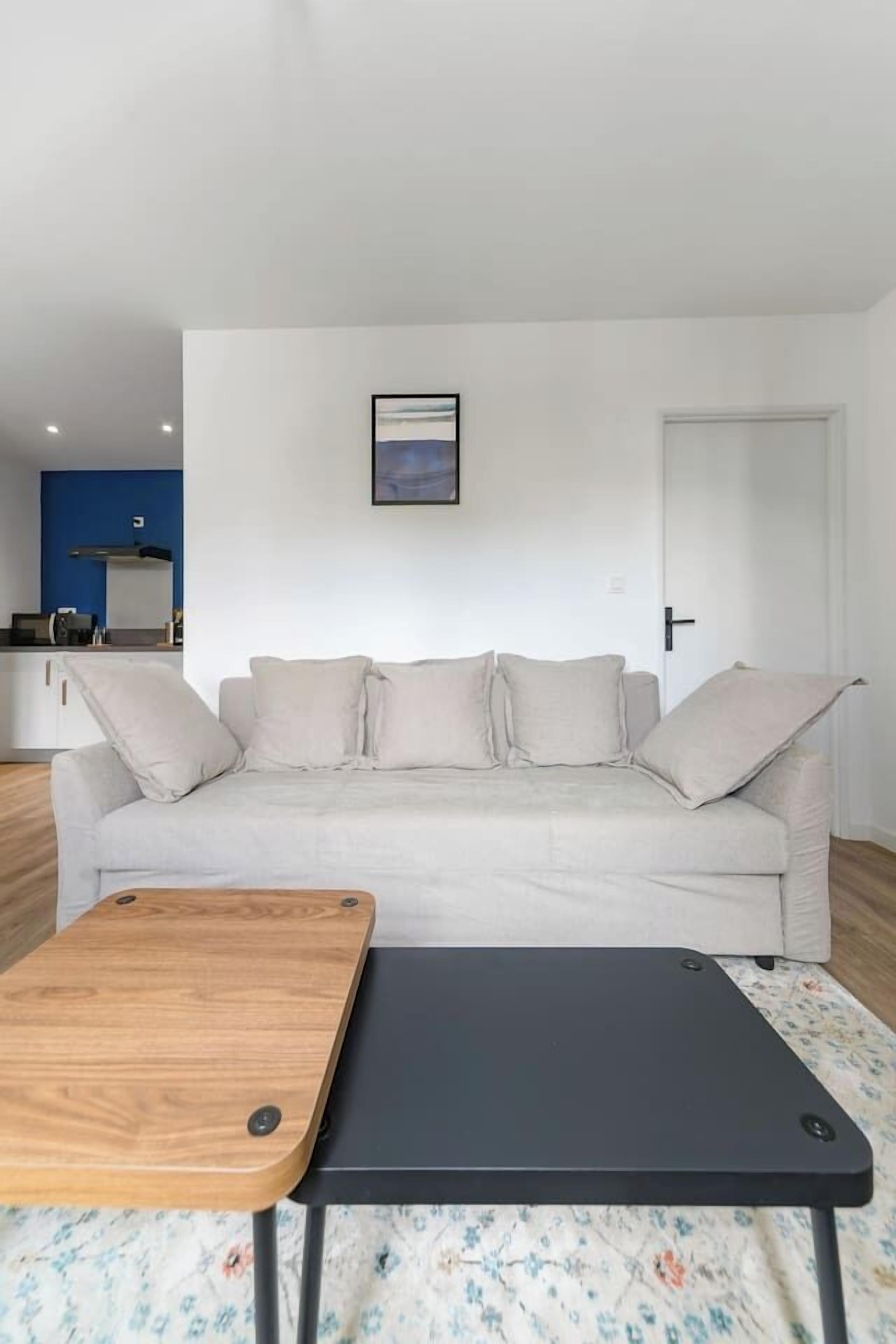 A living room with a sofa, a wooden coffee table, and a black side table.