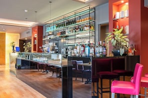 A bar area with shelves of liquor bottles, a coffee machine, and seating. - Fortyfive Squared (Rome)