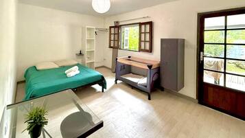 Une chambre à coucher comprenant un lit, un bureau, une armoire et une fenêtre donnant sur un beau paysage.
