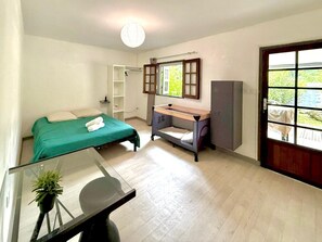 Un dormitorio con cama, escritorio, armario y ventana con vistas.