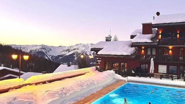 A pool area with snow-covered surroundings and a mountain backdrop. - 250m from ski slopes, 4th floor, view ski slopes, swimming pool, balcony, ski locker, 34m² (La Plagne)