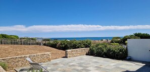 A rooftop terrace with a stone wall, a seating area, and a view of the sea. - House near wild coast and castle (Quiberon)