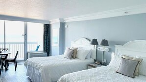 A hotel room with two beds, a balcony, and a dining area. - ~The Shoreline~ Oceanfront Studio Condo (Daytona Beach)